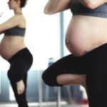 Sport Schwangerschaft Bewegung / Schwangere Frau macht eine Yoga-Übung im Stehen und hält dabei das Gleichgewicht