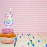 3 Jahre, 4. Lebensjahr (Muffin with cream and number 3 for birthday on a pink background, copy space, holiday background. Happy birthday greetings for a three year old child )
