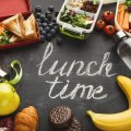 gesunde Alternativen (Schruftzug Lunchtime umgeben von Obst und Lunchboxen)