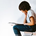 Buchtipps, Bücher 2023 (lesendes Kind auf einem Bücherstapel)
