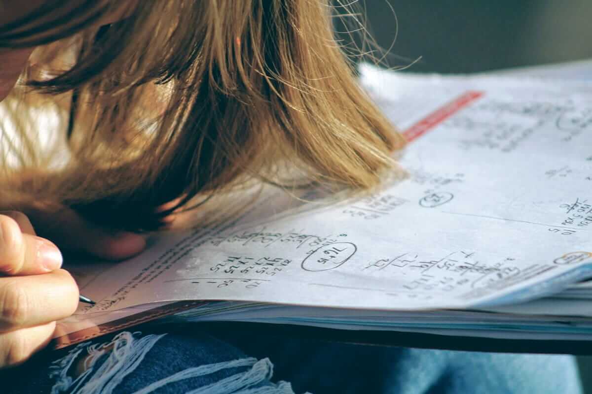 Hausaufgaben, Lernzeit, Hausaufgabenhilfe (Frau in blauer Jeansjacke mit weißem Papier)
