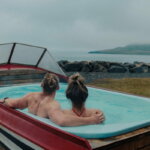 Wellness (Zwei Personen in einem Boot auf einem Dock)