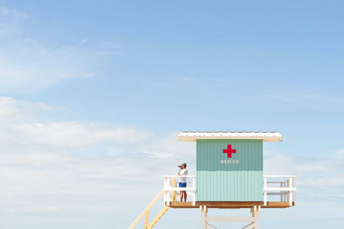 Erste-Hilfe-Tipps (Weißes und rotes hölzernes Rettungsschwimmerhaus unter blauem Himmel tagsüber)