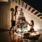 Familientradition (Familie, die ihren Weihnachtsbaum verziert)