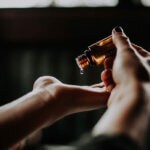 CBD-Öl (Person mit Braunglasflasche)