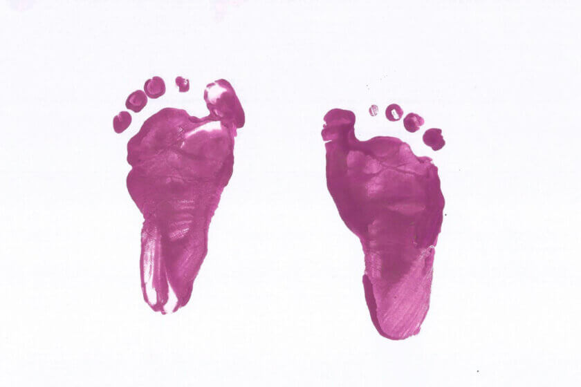 ElterngeldPlus (Zwei violette Babyfußabdrücke auf weißem Hintergrund – Symbol für Geburt und Familienzuwachs)