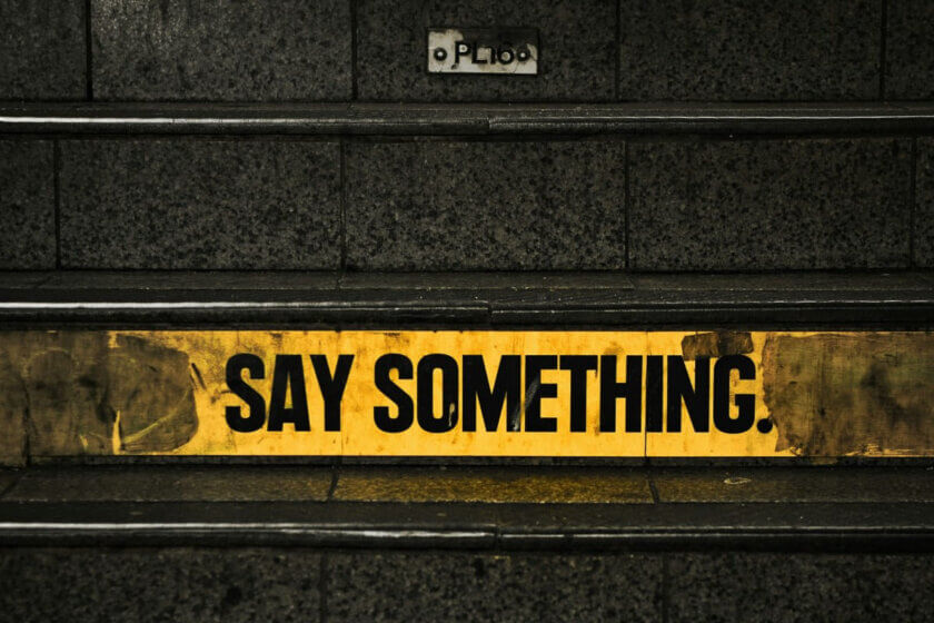 Wenn Kinder weniger erzählen / Schild mit der Aufschrift ‚Say something‘ als Symbol für die Aufforderung, ins Gespräch zu kommen.