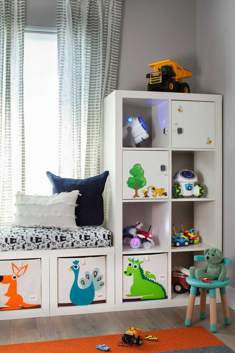Kinderzimmer aufräumen / Kindgerechtes Aufbewahrungssystem: Niedriges Regal mit offenen Fächern und beschrifteten Boxen für verschiedene Spielzeugkategorien