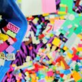 Kinderzimmer aufräumen / Bunte Lego-Steine chaotisch in blauer Aufbewahrungskiste – typisches Kinderzimmer-Chaos beim Spielzeug aufräumen