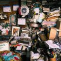 Messie Eltern / Ein vollgestellter Raum mit Stapeln aus Papieren, Gegenständen und persönlichen Erinnerungsstücken – typisches Bild einer Messie-Wohnung.