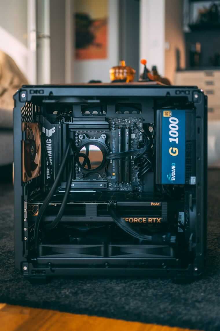 Der erste Gaming-PC fürs Kind: Was Eltern über Budget, Spiele, USK und Jugendschutz wissen sollten Geöffneter Gaming-PC auf dem Wohnzimmerteppich, Hauptplatine mit Wasserkühlung, Grafik-karte und Netzteil sind sichtbar